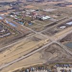 Bridge construction adjacent to the intersection of Highway 22X and James McKevitt Road / Spruce Meadows Way, with nearby stormwater ponds and Spruce Meadows (looking southeast)