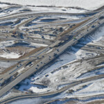 View of the interchange with eastbound and westbound traffic realigned onto the ultimate westbound lanes - allowing for the demolition and upgrade of the old portion of Highway 22X (looking southwest)