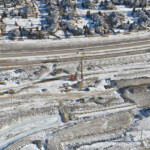 Driving piling for the east abutment of the new pedestrian bridge providing access between Woodbine and the Tsuut'ina Nation (looking east)