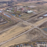 Bridge construction adjacent to the intersection of Highway 22X and James McKevitt Road / Spruce Meadows Way, with nearby stormwater ponds and Spruce Meadows (looking southeast)